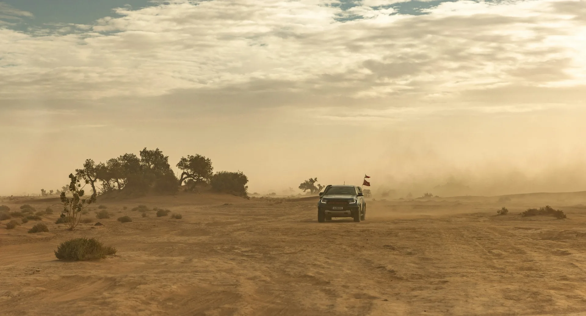 Private 4x4 crossing a desert track beside the Erg Chebbi dunes near Merzouga